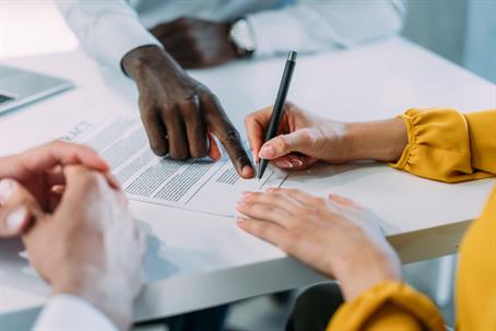 couple signing document with a lawyer